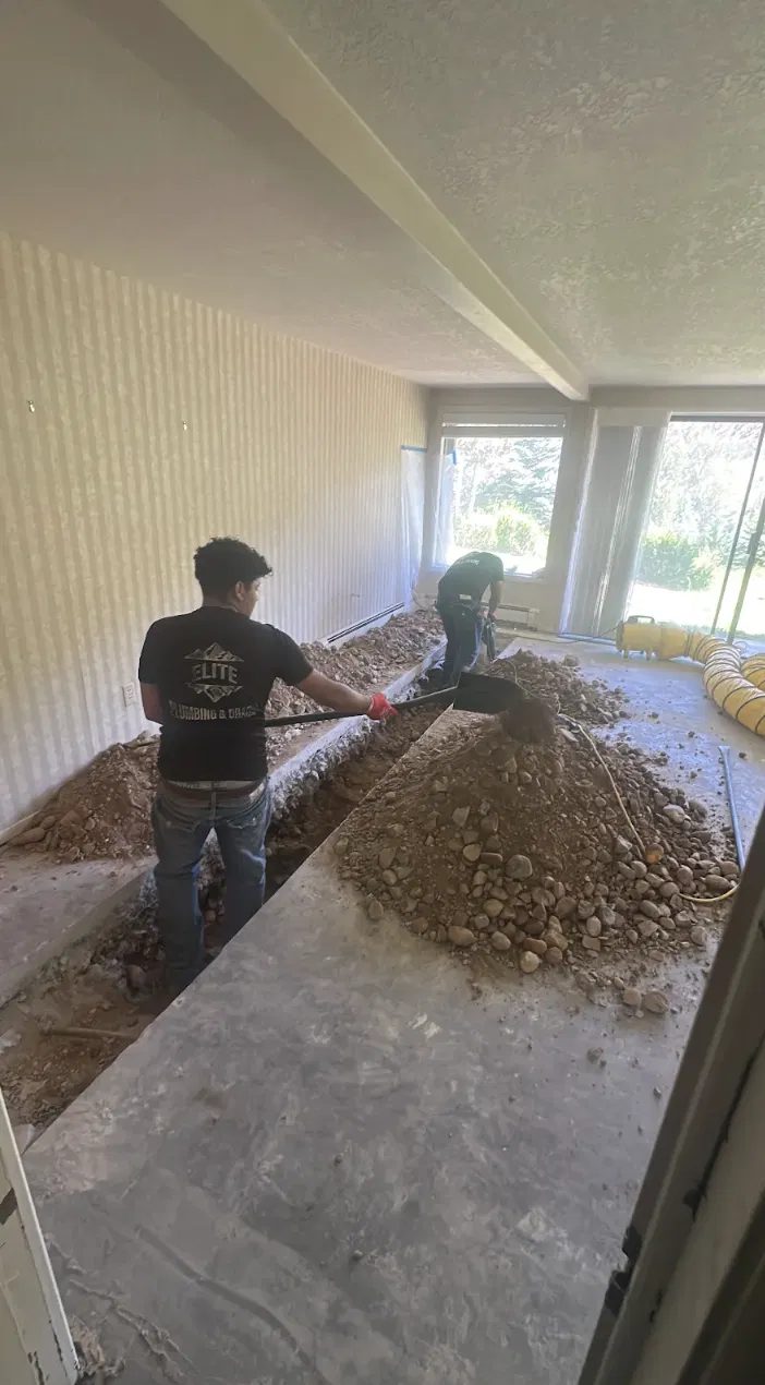 Elite Plumbing & Drains technician trenching a slab for a repipe
